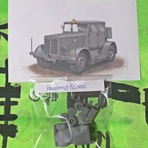以下が含まれることがあります： Hanomag SS100トラックのグレーのプラスチック製モデルキット。キットにはトラックのボディ、ホイール、その他の部品が含まれています。キットは、透明なプラスチック製の袋に詰められており、白いラベルには「Hanomag SS100」と記載されています。