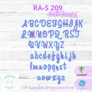 May include: A colorful alphabet font with a rhinestone design. The letters are in a light blue outline with a purple fill. The font is called "RA-S 209" and is described as "TTF Typeable Rhinestone Font".