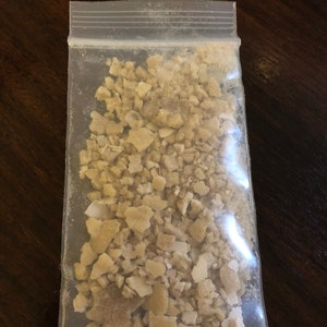 May include: A clear plastic bag filled with small, irregular pieces of light brown and white material.