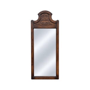 May include: A rectangular wall mirror with a dark brown wooden frame. The top of the frame features a decorative arched crest with carved scrollwork details. The mirror glass is clear and reflective, set within the straight vertical wooden sides.