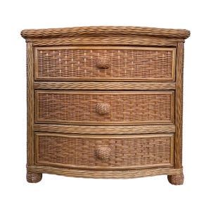 May include: A three-drawer wicker chest in a natural brown color. The drawers have round knobs and a woven pattern. The chest has a curved bottom and a decorative top edge. The overall design is rustic and suitable for bedroom or living room storage.