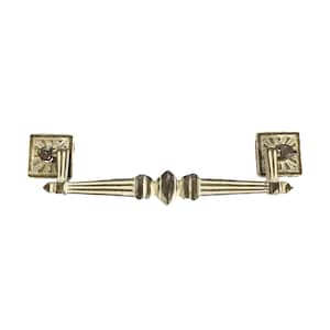 May include: A white and gold metal drawer pull with a decorative design. The pull has a rectangular shape with a center bar and two decorative ends.