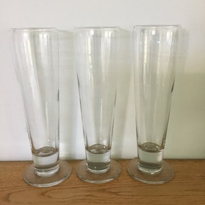 Three tall footed Pilsner beer glasses