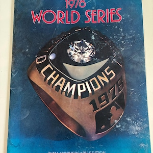 May include: A vintage 1978 World Series program cover. The cover features a championship ring with the words "CHAMPIONS 1978" and a large diamond. The text "1978 WORLD SERIES" is in red. The program is the 75th Anniversary Edition.