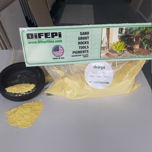 May include: A yellow bag of decorative filler for landscaping and crafts. The bag is labeled "difepi" and "www.difepitiles.com". The label also lists the products offered by the company: sand, grout, rocks, tools, pigments, and decorative fillers.