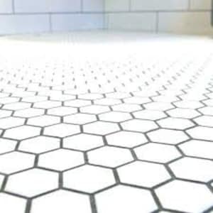 May include: White hexagonal ceramic tiles with black grout lines. The tiles are arranged in a repeating pattern.