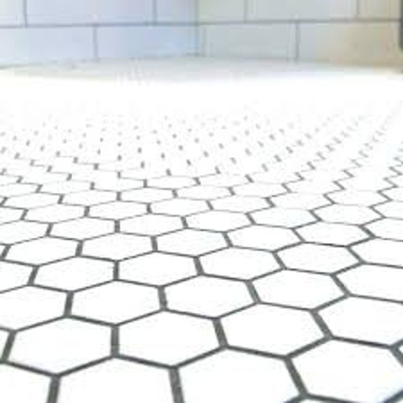 May include: White hexagonal ceramic tiles with black grout lines. The tiles are arranged in a repeating pattern.