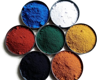 Puede incluir: Siete cuencos pequeños llenos de pigmentos de diferentes colores. Los colores son azul, blanco, rojo, verde, amarillo, negro y naranja.