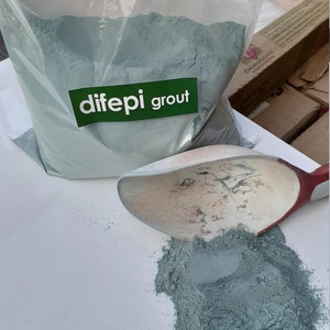 May include: A bag of blue-green grout powder with the label "difeepi grout" on the front. A scoop of the powder is being poured out of the bag onto a white surface.