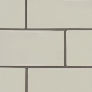 May include: A close-up of a white tiled wall with grey grout lines. The tiles are arranged in a staggered pattern.