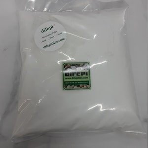 Puede incluir: Una bolsa de plástico blanca llena de relleno decorativo blanco. La bolsa tiene una etiqueta verde con el texto "difepi Decorative Filler Sand Stone Ground difepitiles.com".