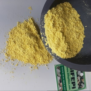 May include: Yellow powder in a black bowl and on a white surface. The powder is a food ingredient called "Difeptiles". The text on the label reads "Difeptiles.com www.Difeptiles.com 19170 SW 106 Ave. Miami, FL 33157"