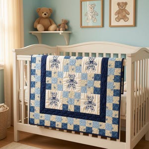 May include: A crib quilt featuring a patchwork design in shades of navy blue, light blue, and cream. The quilt displays repeating patterns of teddy bears and swirling motifs, finished with a dark navy blue border, draped over a white wooden crib.