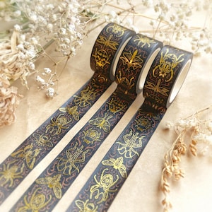 May include: Four rolls of decorative washi tape with a dark blue background and gold insect illustrations. The tape features various insects, including beetles, butterflies, and dragonflies, with a reddish-brown decorative pattern.