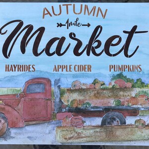 May include: A watercolor painting of a red vintage truck with a wooden bed filled with pumpkins. The truck is driving on a dirt road with a blue sky in the background. The text "AUTUMN MARKET" is written in brown letters above the truck. The text "1 mile" is written in white letters below the truck. The text "HAYRIDES", "APPLE CIDER", and "PUMPKINS" is written in brown letters below the truck.