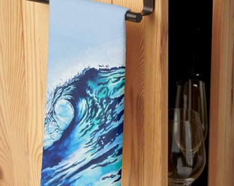 May include: A blue and green watercolor wave design kitchen towel hanging on a black metal towel rack.