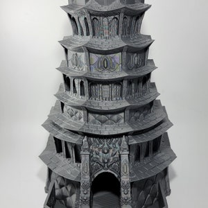 May include: A gray, multi-tiered fantasy tower with intricate architectural details. The tower features multiple levels, arched windows, and decorative carvings. The structure has a pagoda-like design, with a series of overhanging roofs. The tower is approximately 12 inches tall.