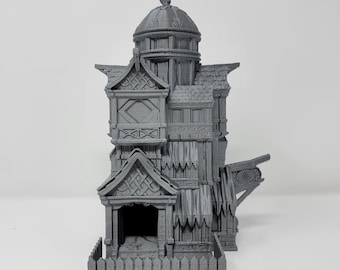 May include: A gray 3D printed model of a multi-level building with a pointed roof and a fence. The building has a detailed exterior with windows and a door.