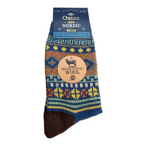 May include: A pair of blue socks with a multi-coloured Nordic pattern in yellow, orange, green, and brown. The packaging features the text Oates Nordic Socks and a circular tag labelled Traditional Wool with an illustration of a sheep.