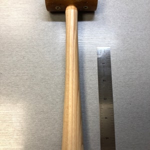May include: A wooden mallet with a brown rubber head and a wooden handle. The handle is about 6 inches long. The head is about 2 inches in diameter.