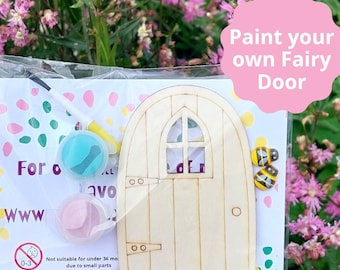Puede incluir: Un kit de puerta de hada de madera con pintura, un pincel y decoraciones de abejas. El kit incluye las palabras "Pinta tu propia puerta de hada".