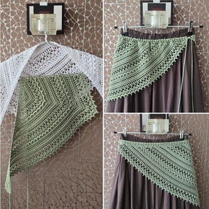 May include: A crochet pattern photo tutorial with text reading CROCHET PATTERN PHOTO TUTORIAL ENGLISH RUSSIAN. The image displays a white lacy shawl and a sage green triangular crochet wrap draped over a brown skirt, showcasing intricate stitch details.