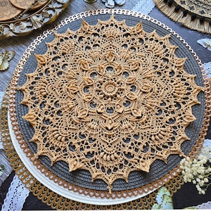 Puede incluir: Un tapete de ganchillo beige con un diseño floral detallado. Se coloca sobre un salvamanteles gris. El texto "CROCHET PATTERN PHOTO TUTORIAL" y "ENGLISH RUSSIAN" es visible en la imagen.