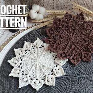 May include: Two crocheted doilies, one in brown and one in cream, on a grey and white round placemat. The text "CROCHET PATTERN" is visible at the top of the image.