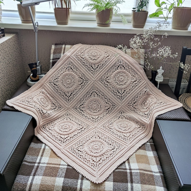 Pu&ograve; includere: Una coperta all'uncinetto di colore rosa chiaro con un delicato motivo floreale. La coperta &egrave; realizzata con un filato morbido e leggero e ha un bordo a frange.