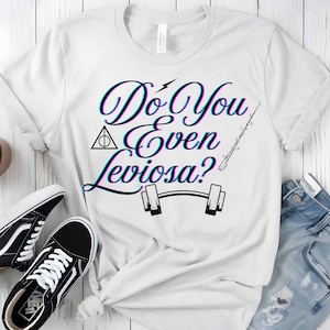 Pode incluir: Camiseta branca com uma estampa gráfica que diz "Do You Even Leviosa?" com um raio, um símbolo de Hogwarts, uma varinha mágica e um peso.