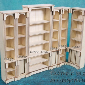 Pu&ograve; includere: Un set di librerie in legno grezzo di diverse dimensioni. Le librerie sono etichettate con le loro dimensioni, tra cui "LBA30", "LBA45" e "LBA80 TALL". Esempio di disposizione mista.