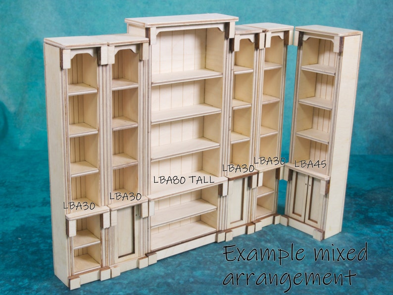 Pu&ograve; includere: Un set di librerie in legno grezzo di diverse dimensioni. Le librerie sono etichettate con le loro dimensioni, tra cui "LBA30", "LBA45" e "LBA80 TALL". Esempio di disposizione mista.