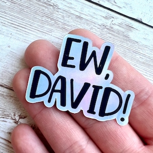 May include: A holographic sticker with the text "EW DAVID!" in black lettering on a rainbow background.