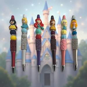 May include: Six pens featuring decorative toppers of various cartoon characters. Each pen has a barrel adorned with colorful beads, rhinestones, and textured accents in shades of red, white, purple, brown, pink, and silver, arranged vertically.