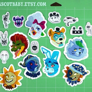 May include: A collection of colorful character stickers on a green cutting mat. The stickers feature various cartoon animal designs, including a bear, bunny, wolf, and alligator. The text "ASCOTBABY.ETSY.COM" is visible at the top.