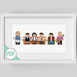 May include: Framed cross-stitch pattern depicting six characters in a pixelated style, similar to Lego figures. The characters are arranged on a brown sofa and green chair. One character is holding a guitar. The image is framed in white.