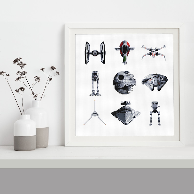 May include: A white framed print with a grid of nine black and white pixelated images of Star Wars spaceships and vehicles. The images include the Millennium Falcon, X-Wing, TIE Fighter, Death Star, and AT-AT.