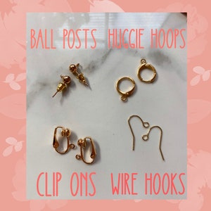 Op de afbeelding: Een close-up van gouden oorbelbeslag, waaronder balpennen, huggie-hoepels, clip-ons en draadhaken. BALL POSTS HUGGIE HOOPS CLIP ONS WIRE HOOKS