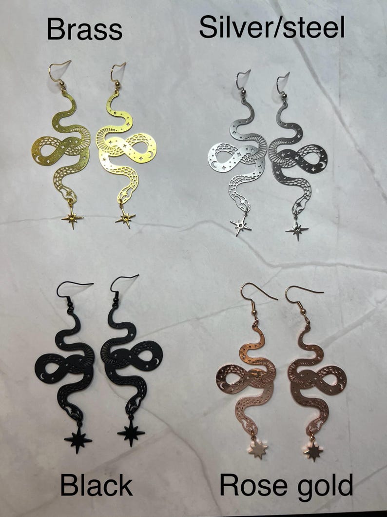 Op de afbeelding: Vier paar slangen oorbellen met een ster bedel. De oorbellen zijn verkrijgbaar in messing, zilver, zwart en ros&eacute; goud.