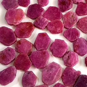 Può includere: Una collezione di circa 50 schegge di rubino rosa. Le schegge hanno una forma irregolare e una finitura grezza e naturale.