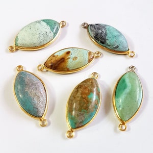May include: Six marquise-shaped jewelry connectors featuring natural stone cabochons in shades of green, blue, and brown. Each stone is set in a gold-toned metal bezel frame with two small circular loops on opposite ends for attachment purposes.