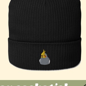 Promotional photo: black beanie with embroidery of a gray cockatiel.