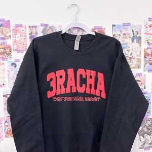 May include: Black sweatshirt with red text that reads "3RACHA WHY YOU MAD, BRAH?"