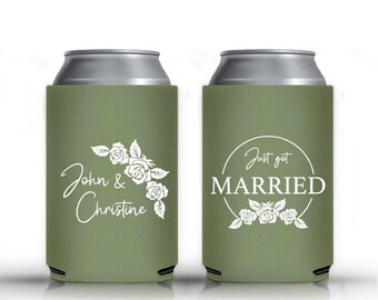 May include: Two olive green can coolers. One cooler has the names "John & Christine" with floral accents. The other cooler says "Just got MARRIED" with floral accents. Both coolers have a silver top.