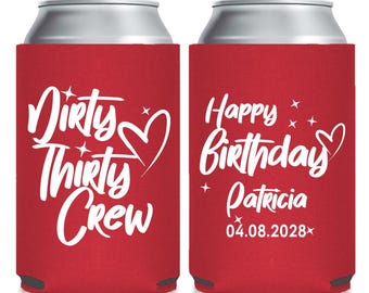 May include: Red can coolers with white text. One says "Dirty Thirty Crew" with a heart. The other says "Happy Birthday Patricia 04.08.2028" with stars and a heart. The coolers are designed to keep beverages cold.
