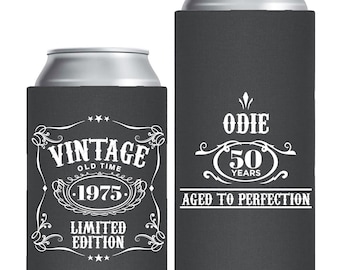 May include: Two dark gray foam can coolers with white printed text. The shorter cooler features the text VINTAGE OLD TIME 1975 LIMITED EDITION. The taller cooler features the text ODIE 50 YEARS AGED TO PERFECTION with decorative flourishes.