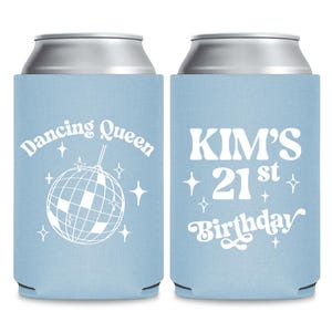 May include: Two light blue can coolers. One has the text "Dancing Queen" with a disco ball graphic. The other says "KIM'S 21st Birthday". Both have white text and star accents.