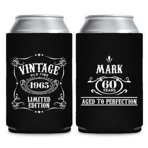 Può includere: Porta lattine neri con testo bianco. Uno recita "VINTAGE OLD TIME 1965 LIMITED EDITION". L'altro recita "MARK 60 YEARS AGED TO PERFECTION".