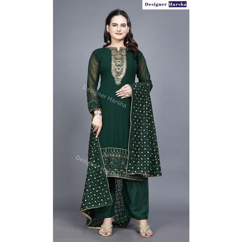 May include: A green salwar kameez with gold embroidery. The kameez has long sleeves and a round neckline. The salwar is a pair of loose-fitting pants. The dupatta is a long scarf that is often worn with a salwar kameez.
