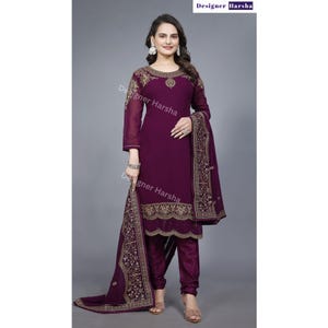 Puede incluir: Un salwar kameez morado con bordados dorados. El kameez tiene mangas largas y un escote redondo. El salwar es un pantal&oacute;n que se ajusta a la cintura y es holgado en los tobillos. El dupatta es una larga bufanda que a menudo se usa con un salwar kameez.